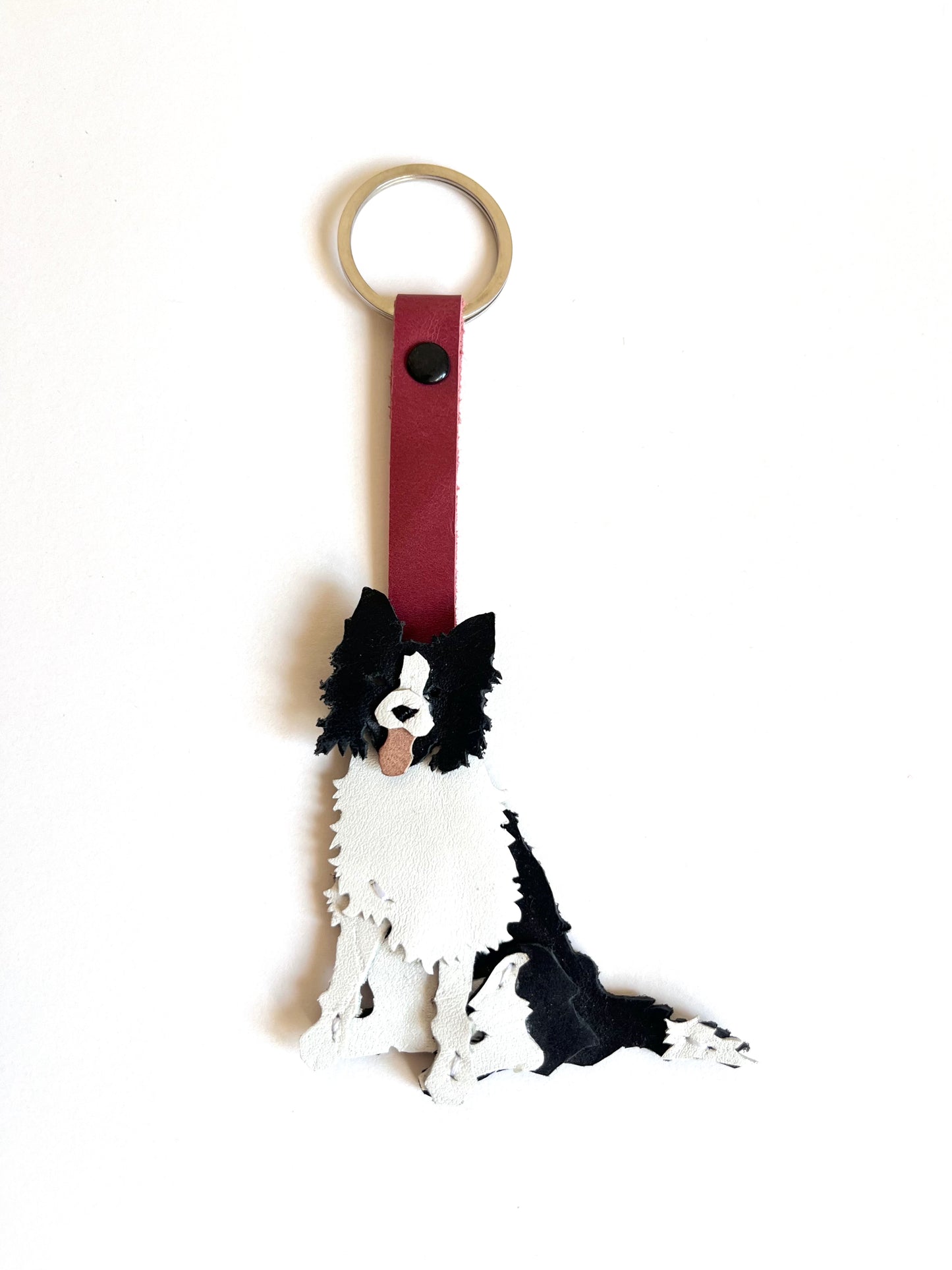 Llavero de Border Collie blanco y negro con correa frambuesa